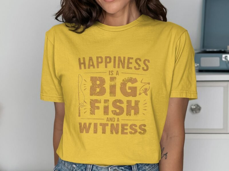Woman in a yellow t-shirt with the phrase "Happiness is a BIG FISH and a WITNESS" printed in brown text.