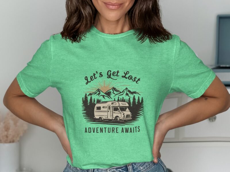 Woman wearing a green t-shirt with the phrase "Let's Get Lost" and a camper graphic amid mountains and trees.