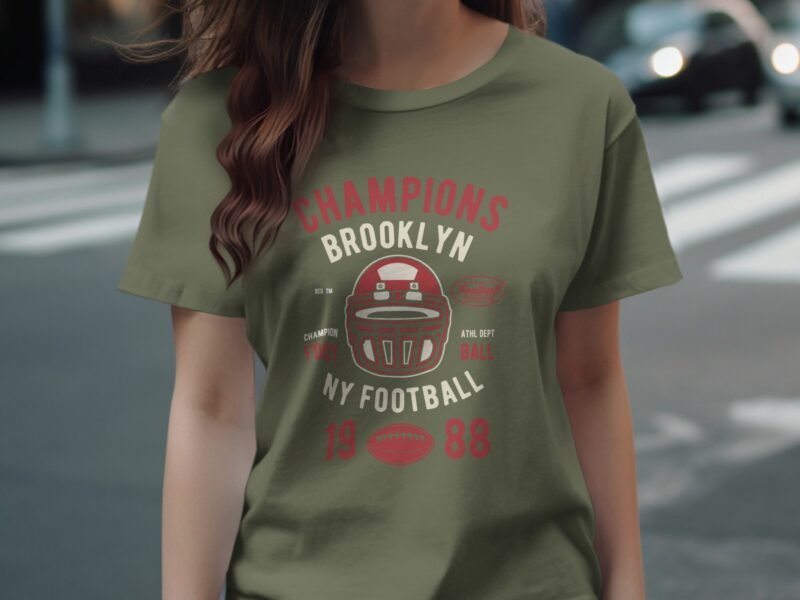 A person wearing an olive green t-shirt with a vintage football design and text reading "Champions Brooklyn 1988."
