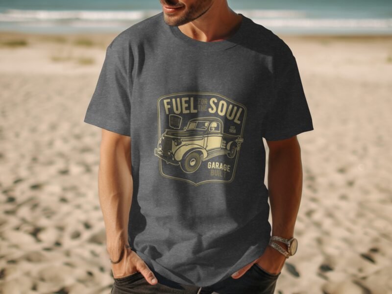 Man wearing a dark gray t-shirt with a vintage truck graphic and text saying "Fuel for the Soul" on a beach.