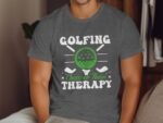 A man wearing a gray T-shirt with the text "GOLFING Cheaper Than THERAPY" and a graphic of a golf ball and clubs.