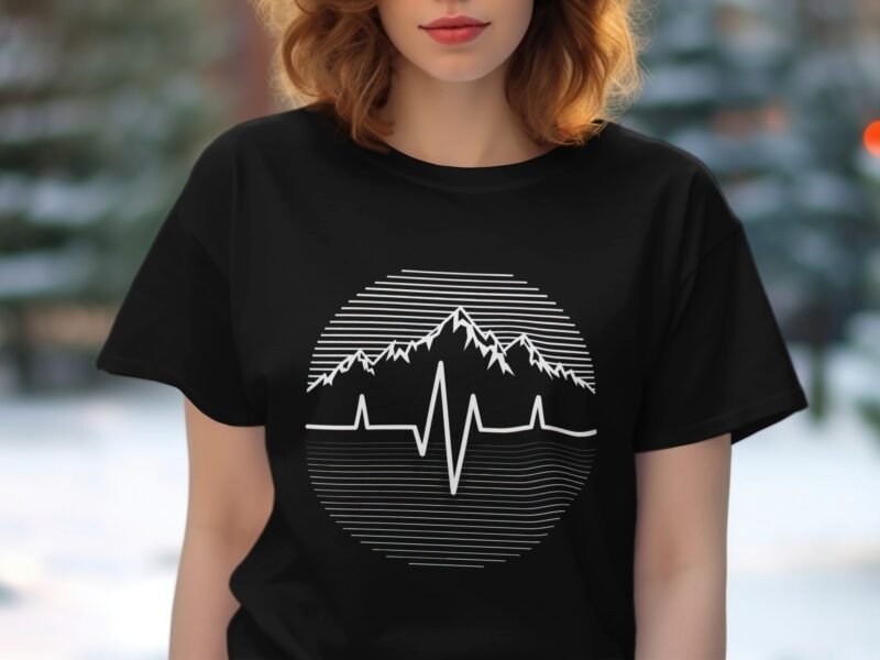 A woman with wavy hair wearing a black t-shirt featuring a mountain and heartbeat line graphic.