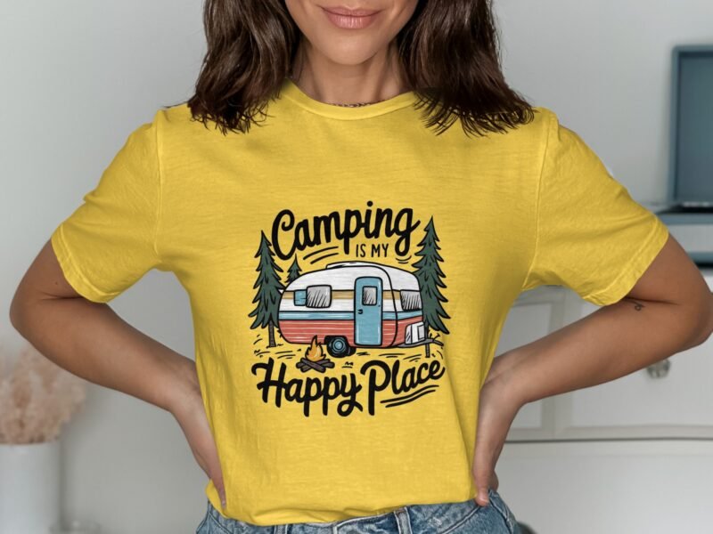 A person wearing a yellow t-shirt with "Camping is my Happy Place" and a camper illustration, smiling in a well-lit room.