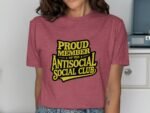 Person wearing a maroon t-shirt with yellow text reading "PROUD MEMBER OF THE ANTISOCIAL SOCIAL CLUB."