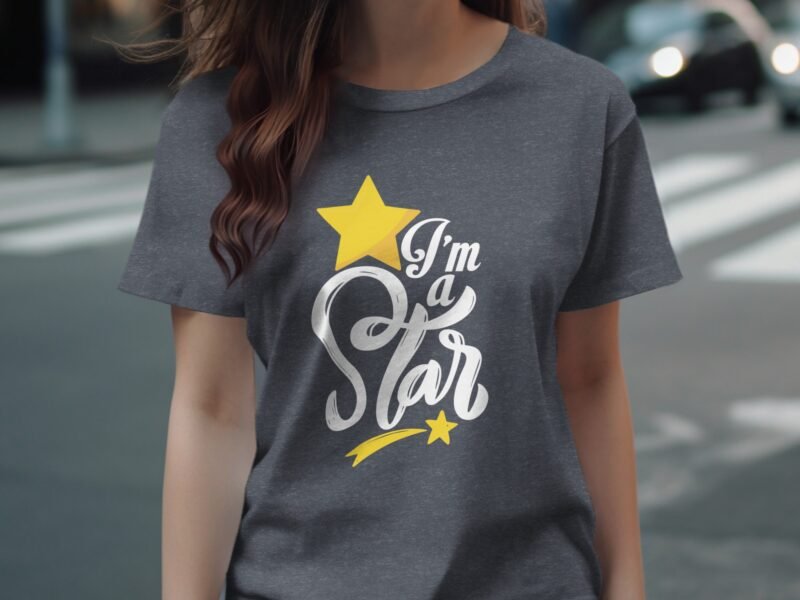 A woman wears a gray t-shirt featuring the text "I'm a Star" with a yellow star graphic, standing on a city street.