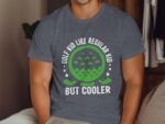 A person wears a gray t-shirt with a graphic that reads "GOLF KID LIKE REGULAR KID BUT COOLER" in green and white.