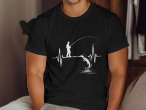 A man fishing on a heartbeat line, with a fish jumping out of water, depicted in white on a black t-shirt.