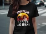 A woman wears a black t-shirt featuring a colorful sunset graphic with the text "SUMMER is here AND SO AM I."