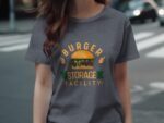 A woman wearing a gray t-shirt featuring a colorful graphic of a burger with the text "BURGER STORAGE FACILITY."
