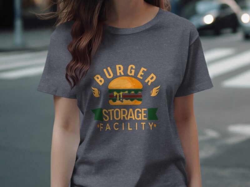 A woman wearing a gray t-shirt featuring a colorful graphic of a burger with the text "BURGER STORAGE FACILITY."