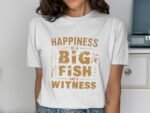 A woman wearing a white t-shirt with the text "Happiness is a BIG fish and a WITNESS" in brown lettering.
