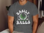 A man wears a gray t-shirt featuring the text "Easily Distracted By Balls" with a golf ball and clubs graphic.