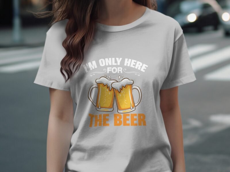A person wearing a light gray t-shirt with "I'M ONLY HERE FOR THE BEER" and graphic beer mugs.