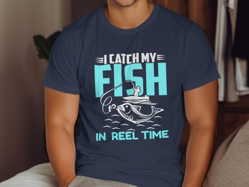 A person wearing a navy t-shirt with the text "I CATCH MY FISH IN REEL TIME" and a fishing graphic.