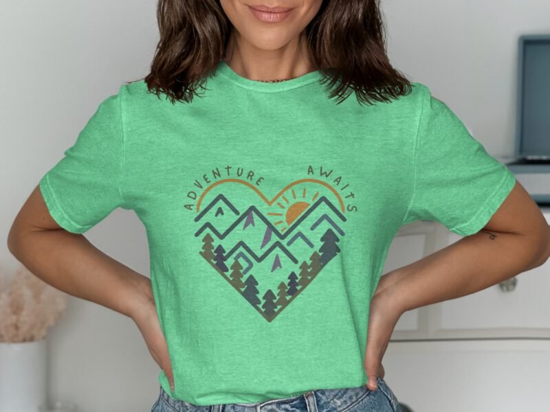 A woman in a mint green t-shirt features a heart-shaped design with mountains and the text "Adventure Awaits."