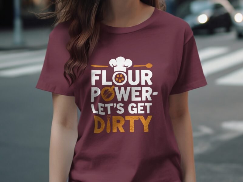 A person wearing a maroon t-shirt with the text "FLOUR POWER-LET'S GET DIRTY" and a chef's hat graphic.