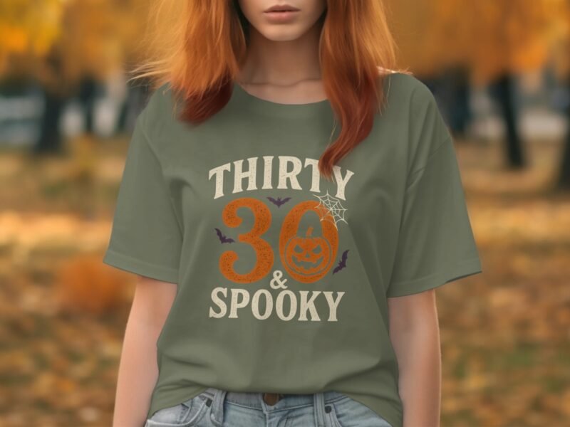 Person wearing a green t-shirt with "THIRTY 30 & SPOOKY" graphic, set against an autumn backdrop.