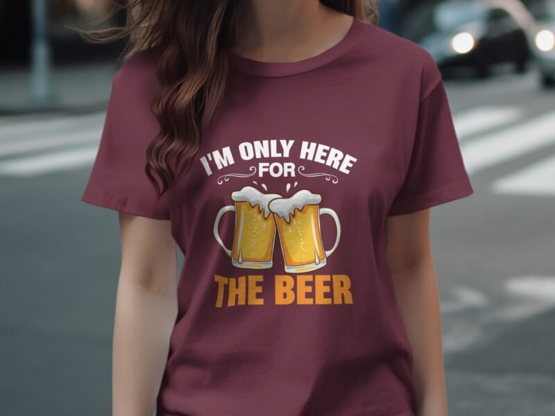 A person wearing a burgundy t-shirt with a beer graphic and the text "I'M ONLY HERE FOR THE BEER" is standing outdoors.