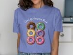 Woman wearing a light blue t-shirt with a graphic of six colorful donuts and text "Check Out My Six Pack."