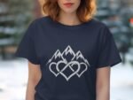 A woman with wavy hair wears a navy t-shirt featuring white mountain peaks and intertwined heart designs.