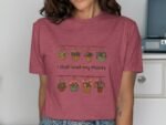 A woman wearing a maroon shirt features a graphic of hanging flower pots and the text "I Just Wet My Plants."