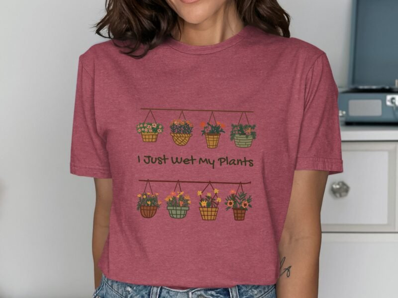 A woman wearing a maroon shirt features a graphic of hanging flower pots and the text "I Just Wet My Plants."