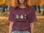 A woman wears a maroon t-shirt featuring cartoon chickens and a ghost with the text "Chick or Tweet." Autumn backdrop.