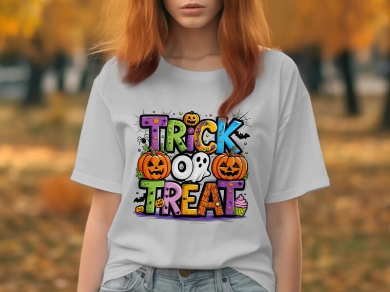 A woman wearing a white t-shirt with a colorful "Trick or Treat" design featuring pumpkins, a ghost, and candy.