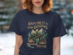 A woman wearing a navy t-shirt with "Happiness is Being Outdoors" and a graphic of mountains, trees, and canoes.