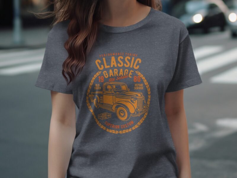 A woman models a gray t-shirt featuring a vintage truck graphic with "Classic Garage" text in orange.