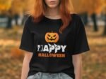 Woman wearing a black t-shirt with a "Happy Halloween" design featuring a pumpkin and a cat, surrounded by autumn trees.