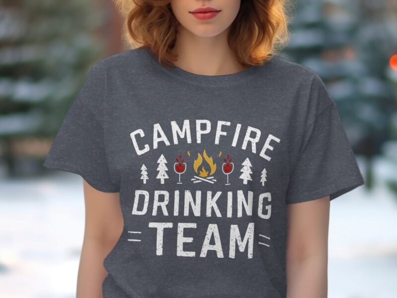A woman wears a gray t-shirt with "Campfire Drinking Team" graphic, featuring trees, cocktails, and a campfire design.