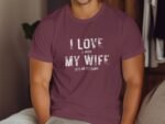 A man in a maroon t-shirt with white text reading "I LOVE it WHEN MY WIFE LETS ME GO FISHING."